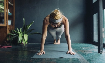 Una chica haciendo una plancha abodominal sobre una esterilla