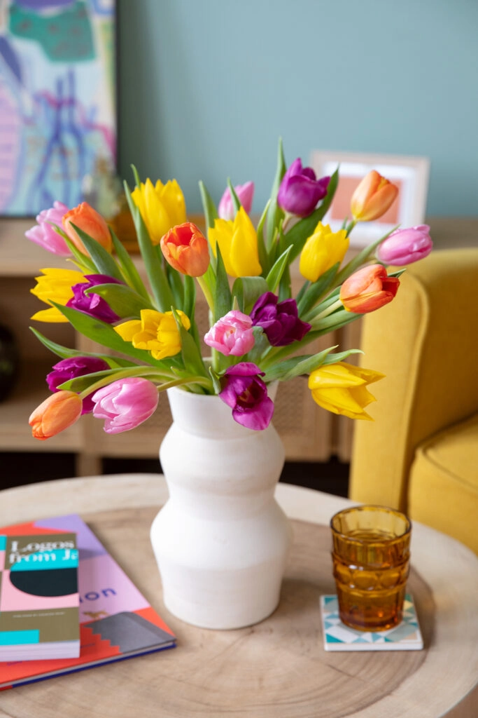 Ramo de tulipanes de colores en un jarrón blanco