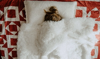 Chica bajo las sábanas, buscando concentrarse