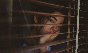 chica triste mirando por la ventana