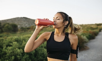 Woman drinking water after workout Relajación post entrenamiento