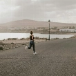 Mujer practicando running sobre asfalto