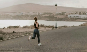 Mujer practicando running sobre asfalto
