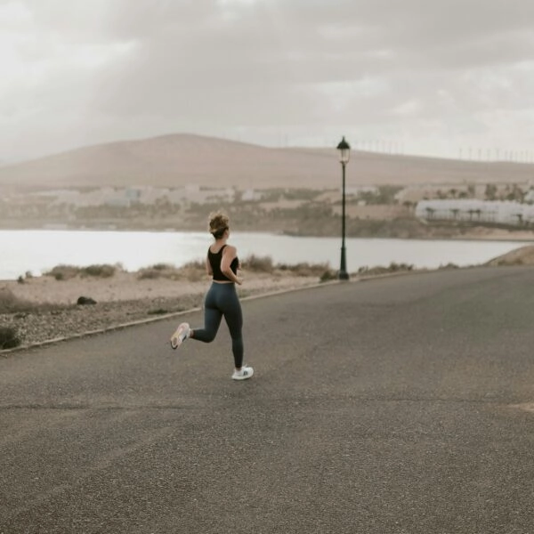 Mujer practicando running sobre asfalto