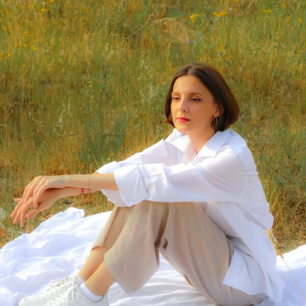 Mujer con actitud pensativa sentada en el campo