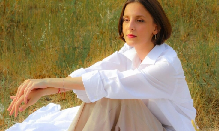 Mujer con actitud pensativa sentada en el campo