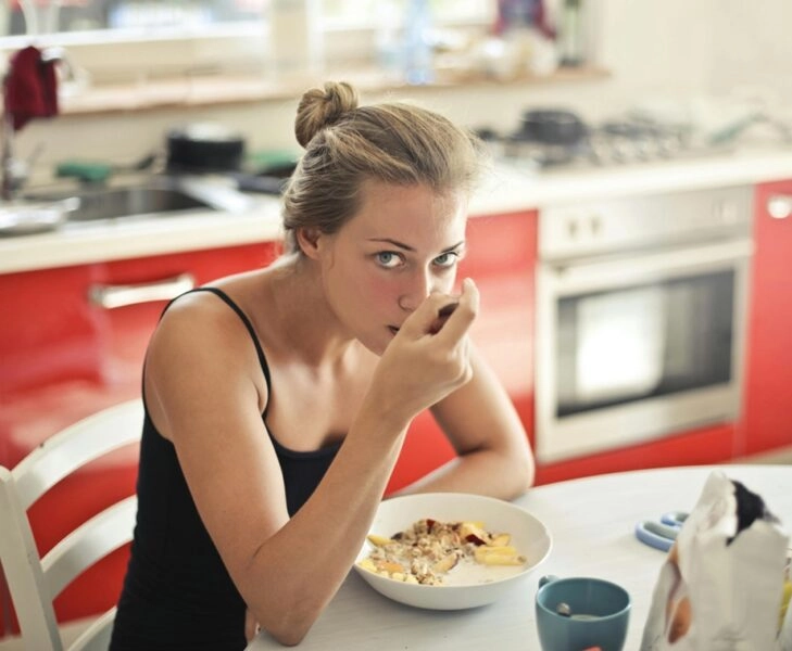 Mujer come con calma para no morderse las mejillas