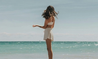 Chica en la playa donde se usan los mejores protectores solares