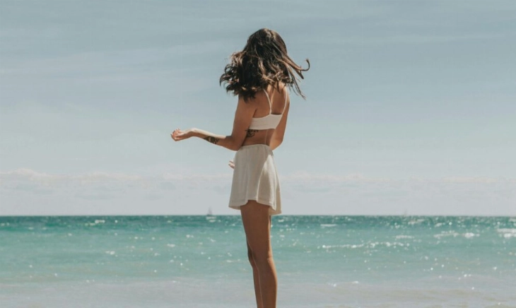 Chica en la playa donde se usan los mejores protectores solares