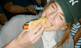 Chica comiendo perrito caliente