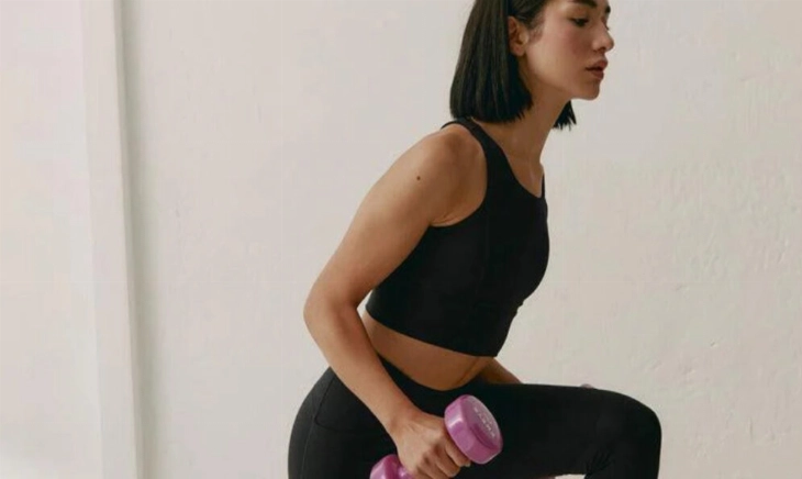 chica joven entrenando fuerza con pesas