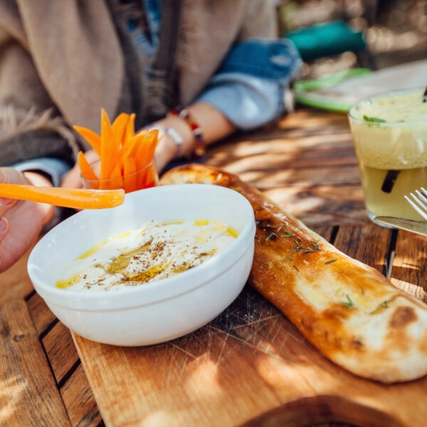 Mujer comiendo hummus, que, gracias a los garbanzos, es rico en fitoestrógenos.
