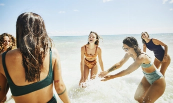 Grupo de chicas bañándose en la orilla del mar