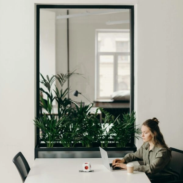Una chica sentada al ordenador con una postura corporal incorrecta