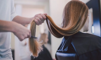 salon-peluqueria-corte-pelo Una chica cortándose el pelo en un salón de peluquería sostenible