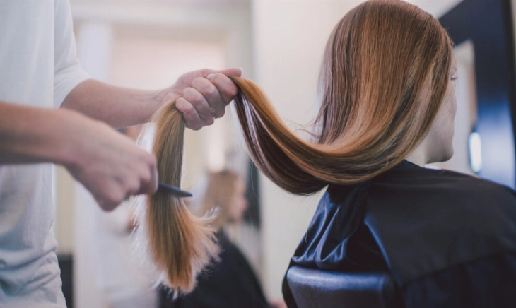 Una chica cortándose el pelo en un salón de peluquería sostenible