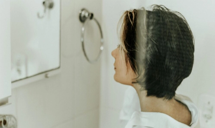 mujer mirándose al espejo por su vello facial