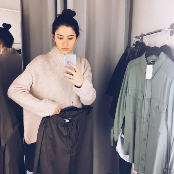 mujer probándose ropa mientras mira su barriga