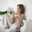 Mujer comiendo un yogur, un probiótico clave en la dieta antiinflamatoria