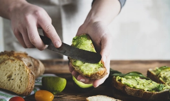 Una mujer prepara aguacate, una grasa que ayuda en menopausia