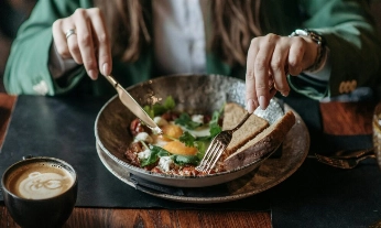 Una mujer tomando un huevo al día