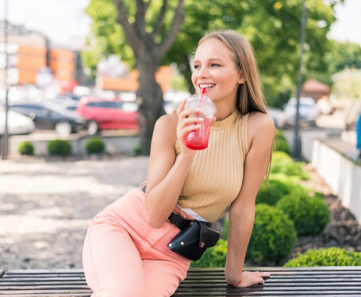 Young pretty woman with cocktail in street cafe