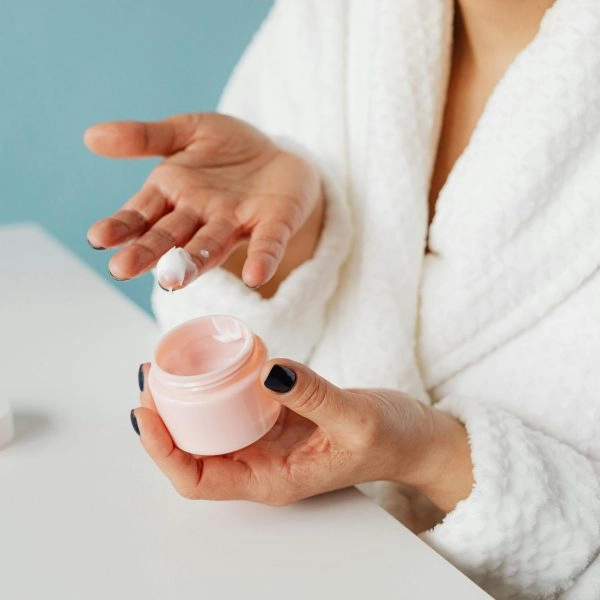 Mujer usando una crema que puede llevar etanol para mejorar su penetración