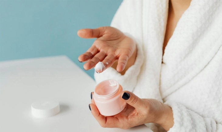 Mujer usando una crema que puede llevar etanol para mejorar su penetración