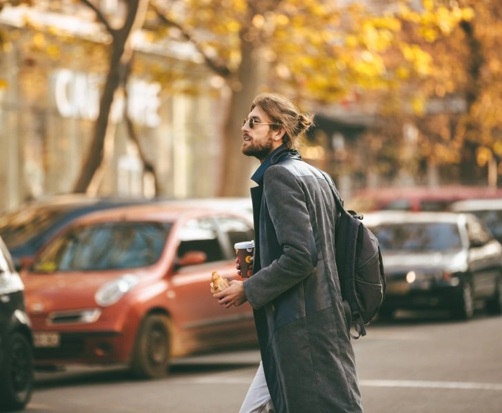 Portrait of a young bearded man wearing sunglasses Hombre camina para ir al trabajo como forma de activar el metabolismo o NEAT