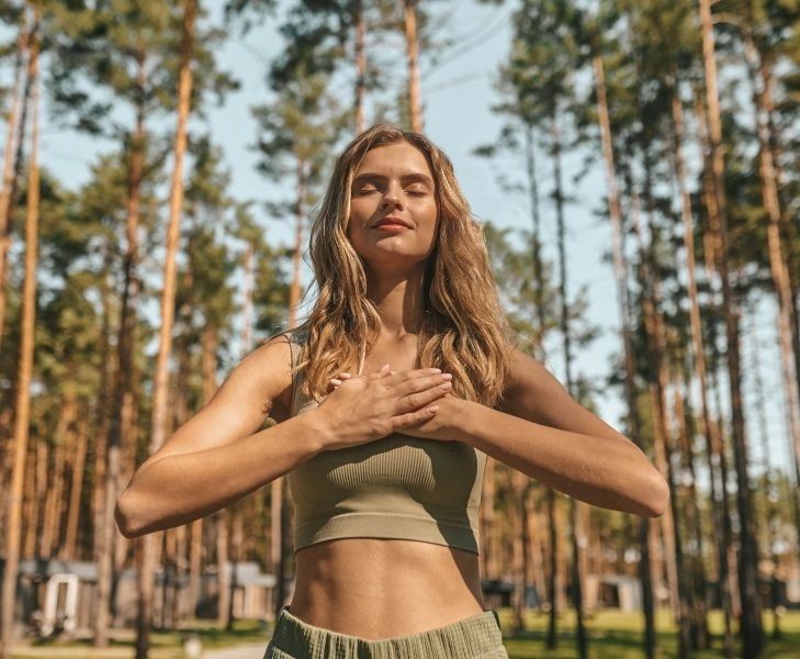 Cute blonde woman practising yoga outside and looking relaxed