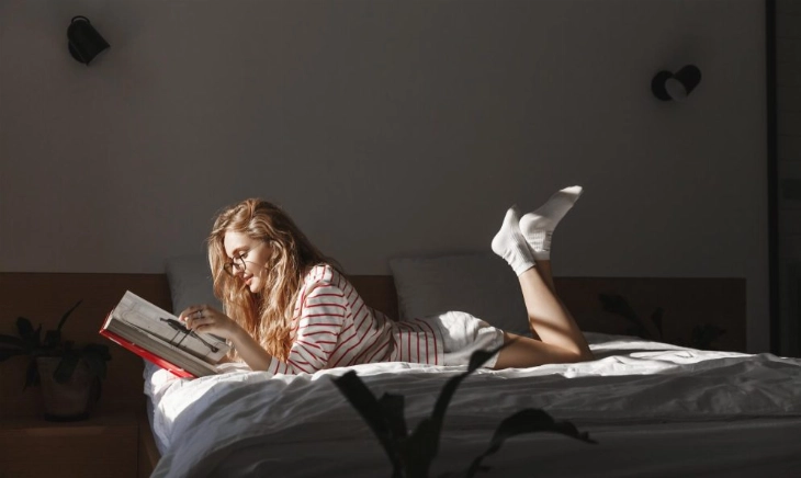 chica en la cama buscando trucos para conciliar el sueño