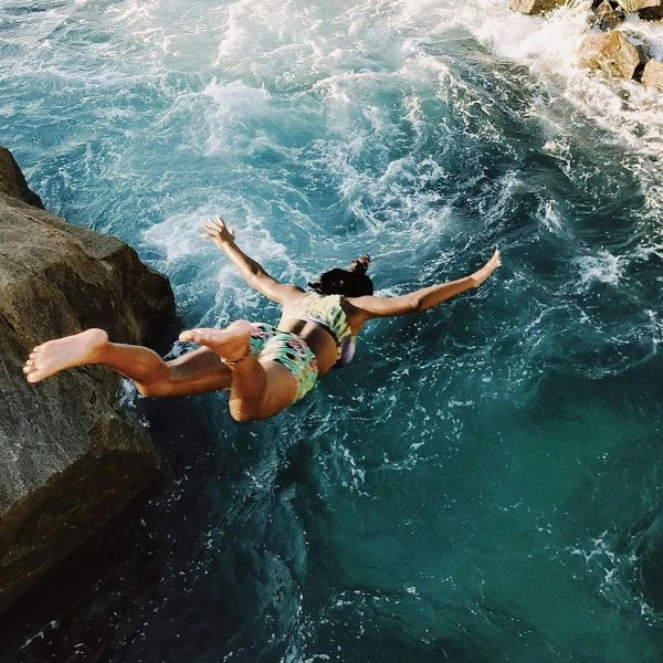 Una persona saltando por un acantilado, símbolo visual de salir de la zona de confort y abrazar la incomodidad que impulsa el crecimiento
