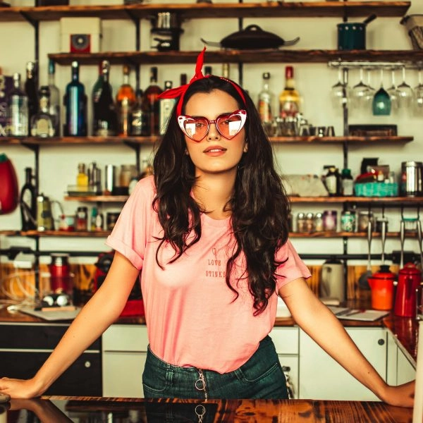 Chica joven en la barra de un bar sin copas de alcohol representando el descenso del consumo de alcohol entre los jóvenes