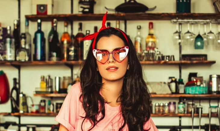 Chica joven en la barra de un bar sin copas de alcohol representando el descenso del consumo de alcohol entre los jóvenes