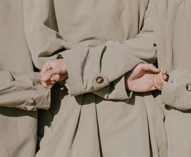 Tres personas entrelazadas de espaldas, simbolizando el desapego como forma de soltar y disfrutar con más libertad.