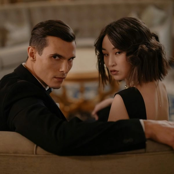 pareja elegante sentada en un sofá mirándose con desconfianza, mentiras en pareja