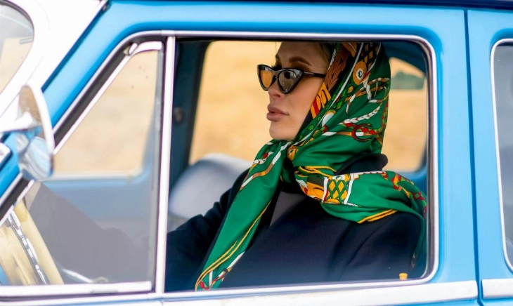 Mujer conduciendo con pañuelo colorido como forma de combatir el estrés postvacacional