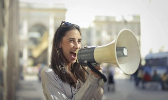 persona joven usando un megáfono en la calle, símbolo de cómo hacer que te escuchen