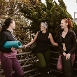 Tres mujeres de mediana edad en mallas de yoga conversan relajadas antes de las charlas de ASISA WeLife Menopausia