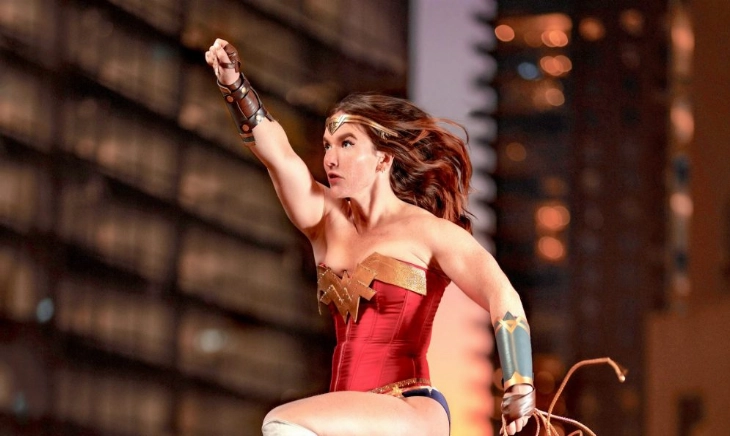 Mujer disfrazada de superhéroe, con capa roja, simbolizando la idea de coraje cotidiano