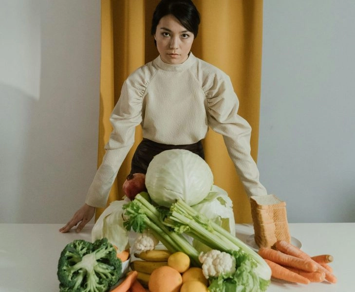 Mujer con alimentos saludables y mala cara por no comer sano