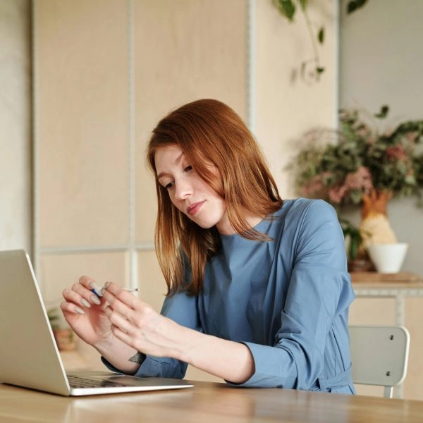 Mujer trabajando frente al ordenador mostrando cómo la inactividad de los glúteos afecta la postura