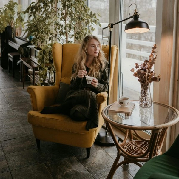 Mujer desayunando yogur junto a la ventana, el mejor momento para tomar yogur según los expertos