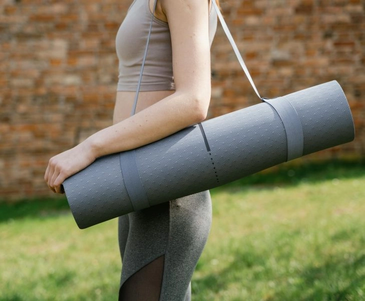 Mujer con estera de yoga
