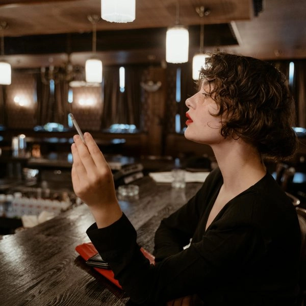 mujer con gesto altivo en un bar, símbolo de cómo tratar con alguien con mucho ego sin perder la calma