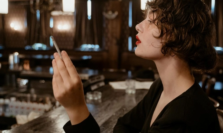 mujer con gesto altivo en un bar, símbolo de cómo tratar con alguien con mucho ego sin perder la calma