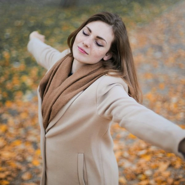 Mujer disfrutando del sol sin protección solar en otoño