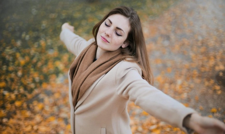 Mujer disfrutando del sol sin protección solar en otoño