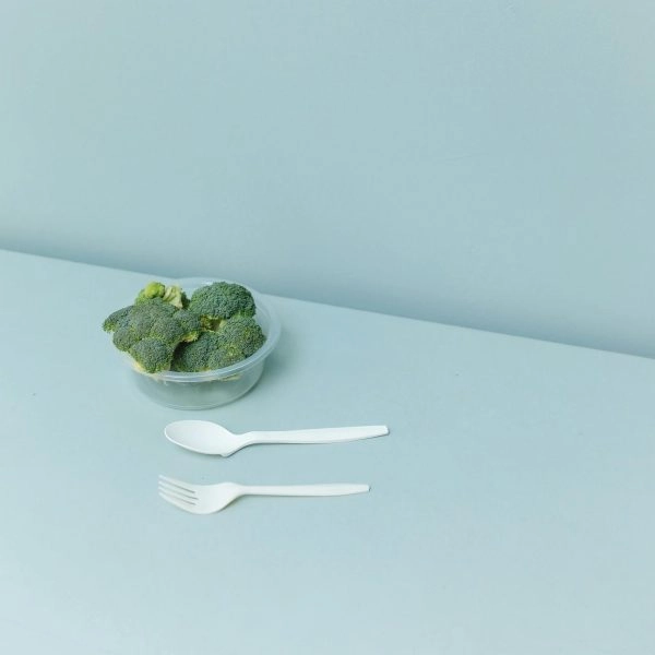 Bol con brócoli y cubiertos sobre una mesa minimalista, imagen asociada al fenómeno Skinni Societé