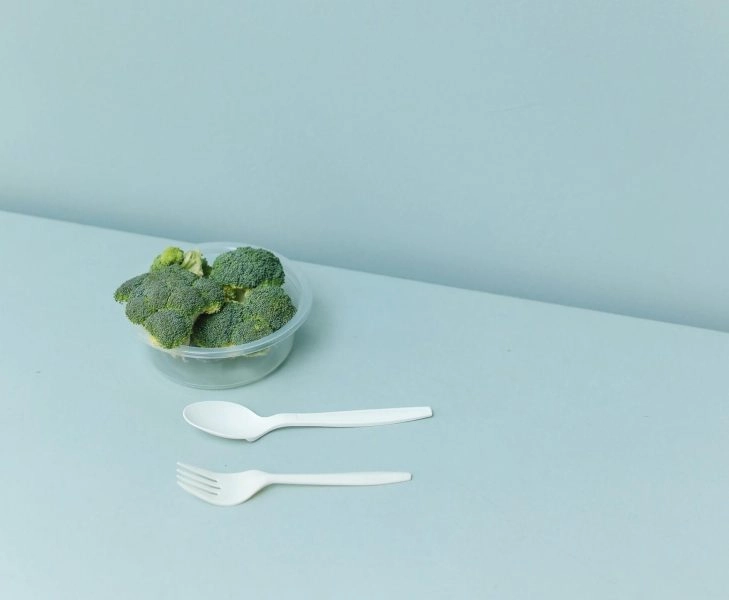 pexels-polina-tankilevitch-5719907 Bol con brócoli y cubiertos sobre una mesa minimalista, imagen asociada al fenómeno Skinni Societé